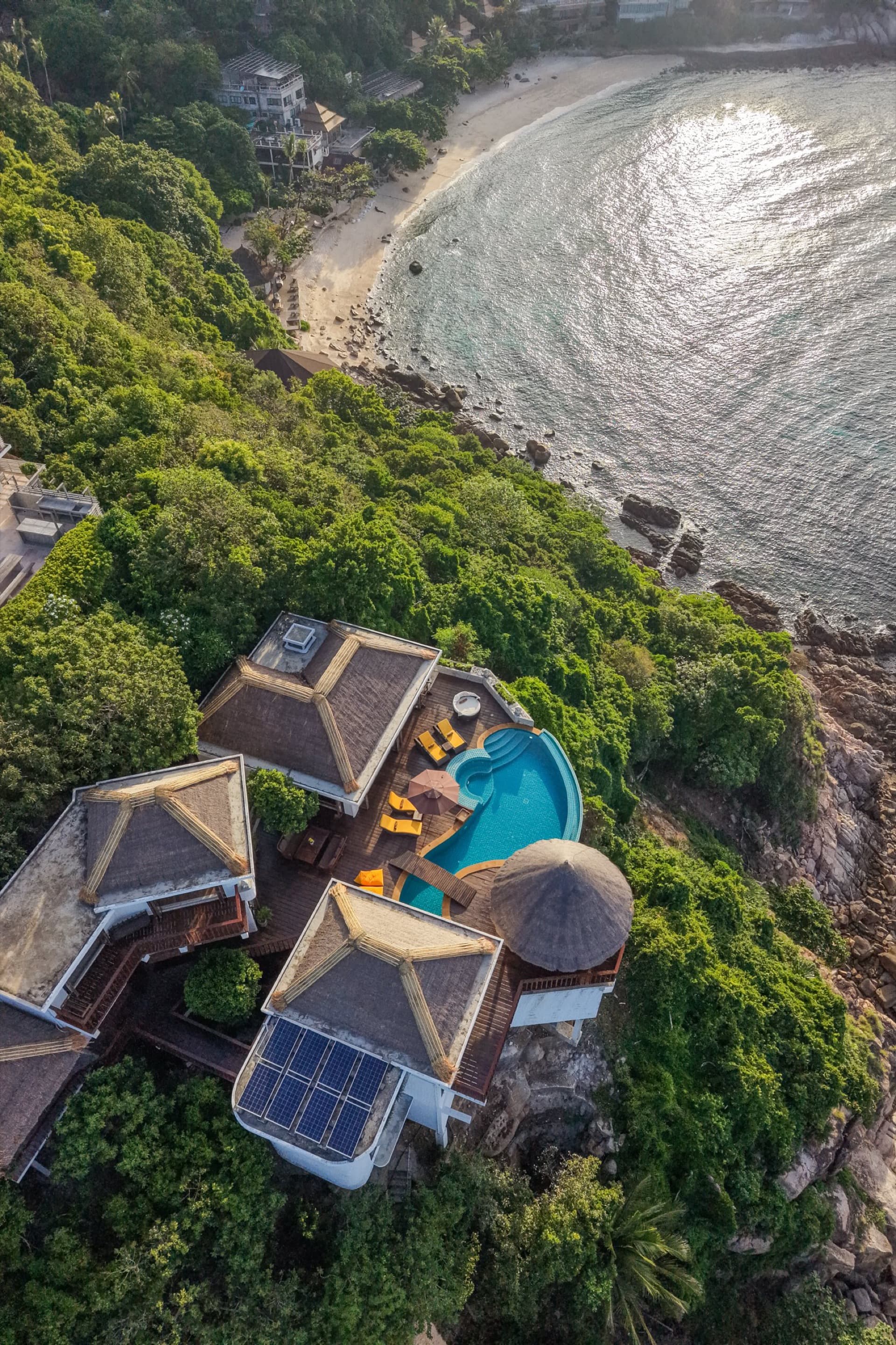 Villas Sabai Jai services — aerial view of a hillside villa, pool deck and beach