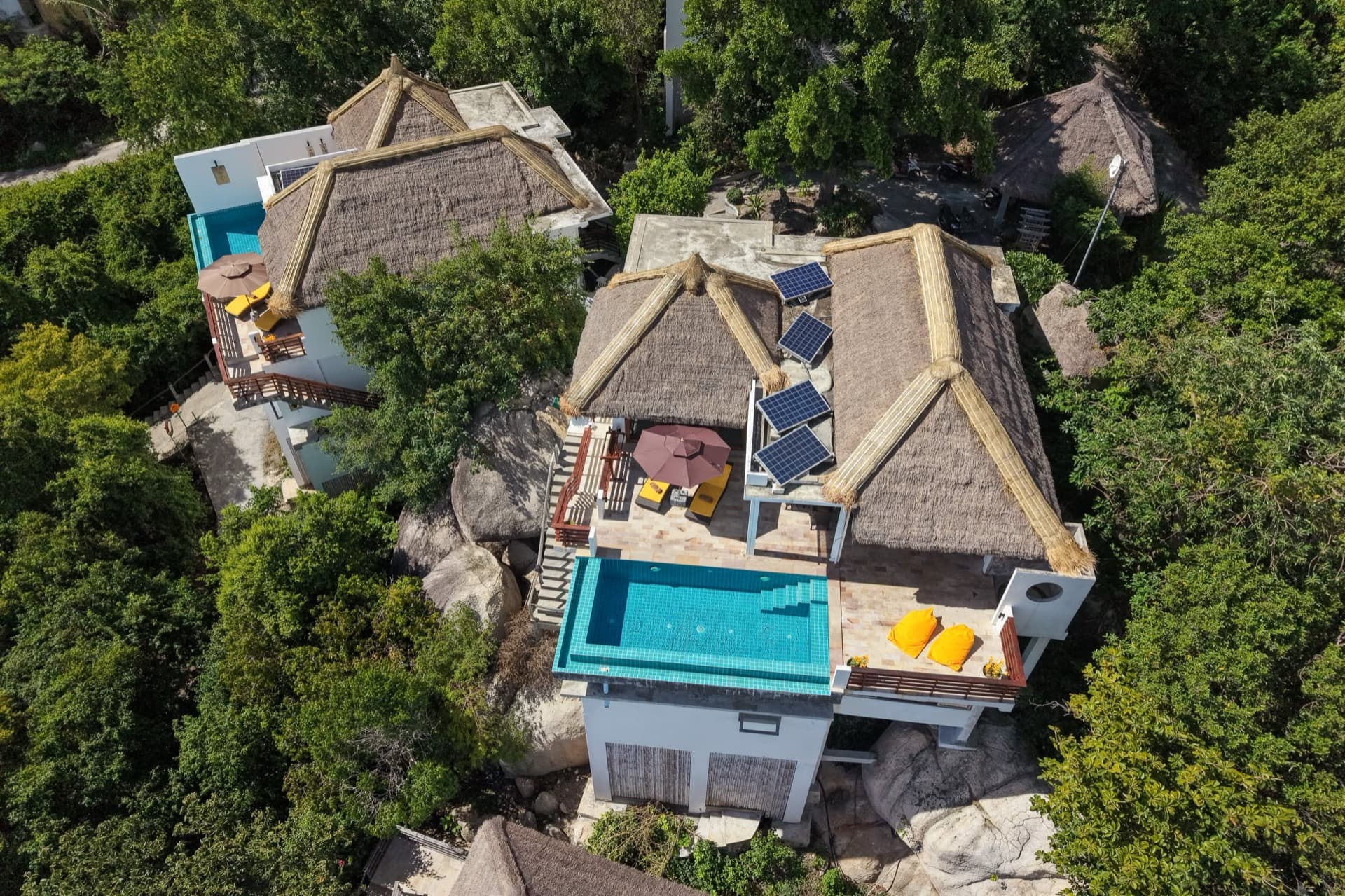 Gecco Villa seen from above with its pool, sun deck and thatched roofs