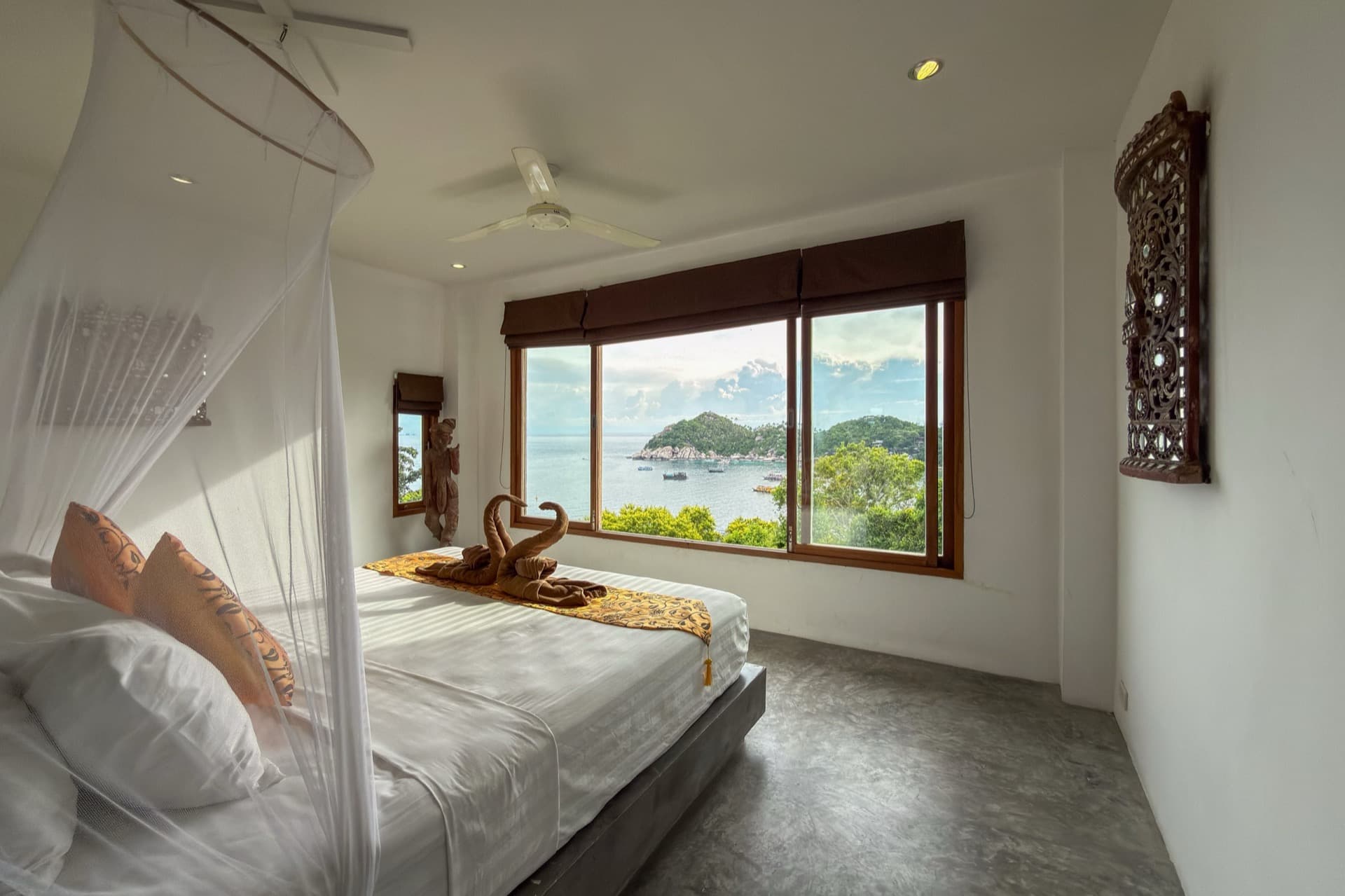 Turtle Villa bedroom with canopy bed and wide window over the bay